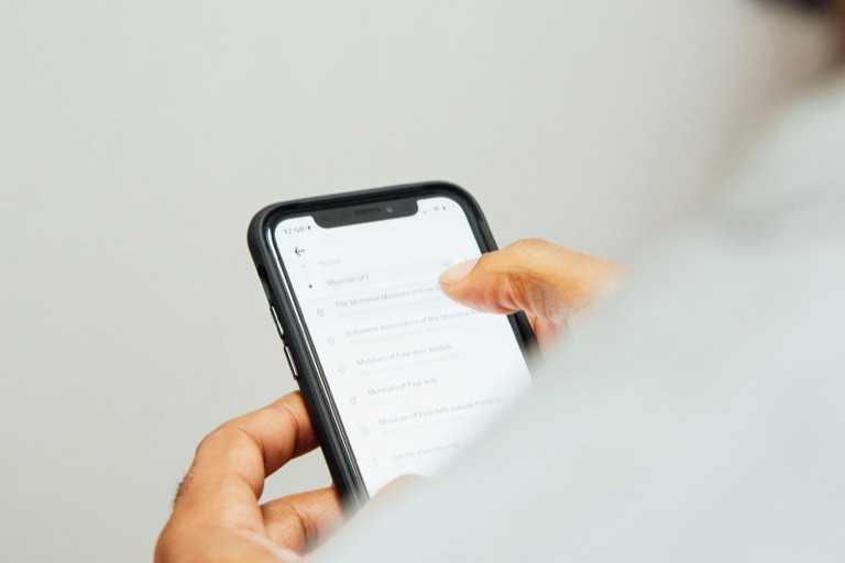 Man håller en mobiltelefon med en app öppen på skärmen.